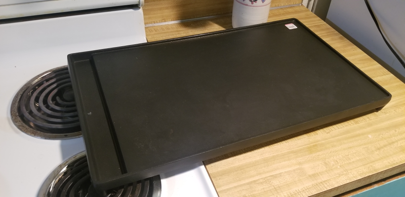 10lbs exactly, according to my fancy kitchen scale. Raised lip around the entire cooking surface. Absolutely no branding whatsoever.